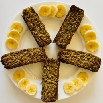 5 slices of banana bread on a plate with bananas