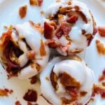 Bacon-Cinnamon-Rolls-on-plate-with-icing-and-bacon-topping