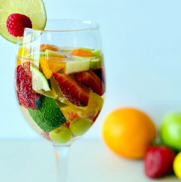 white-sangria-in-wine-glass-with-fruit-and-fruit-in-background