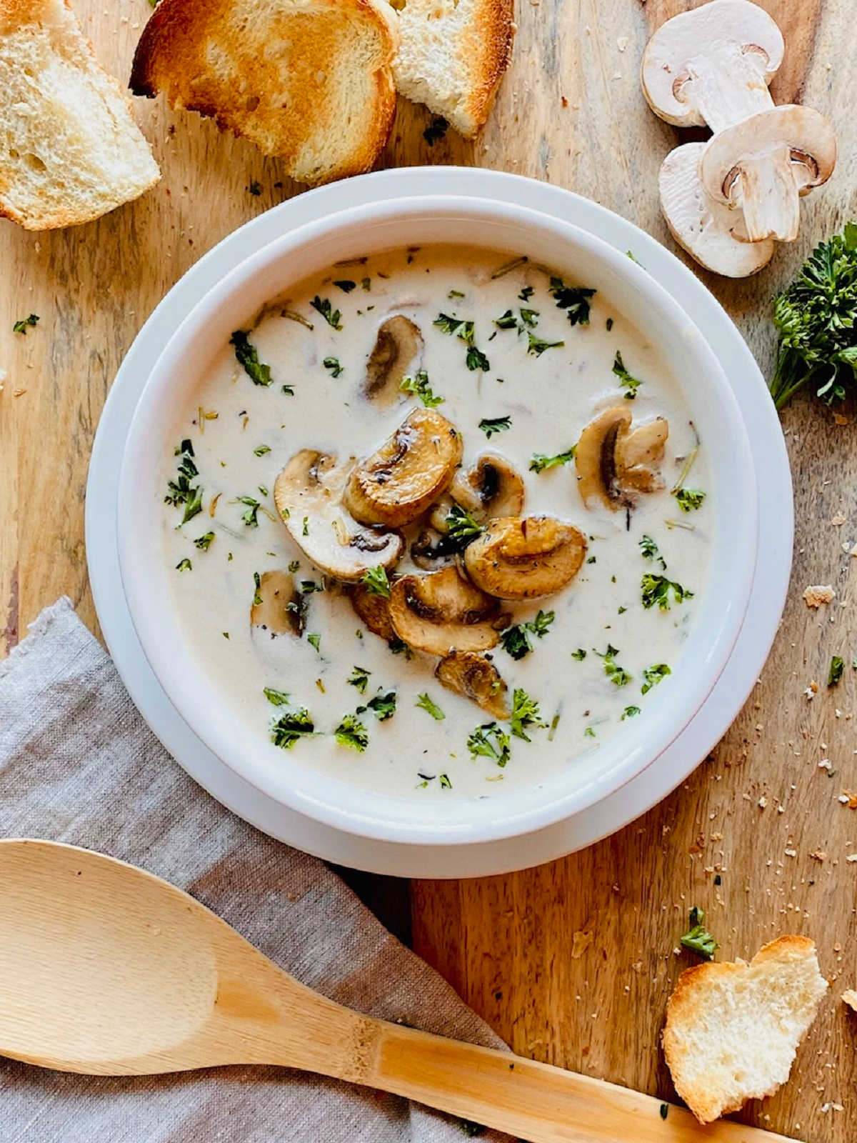 healthy mushroom soup in white bowl next to crusty bread