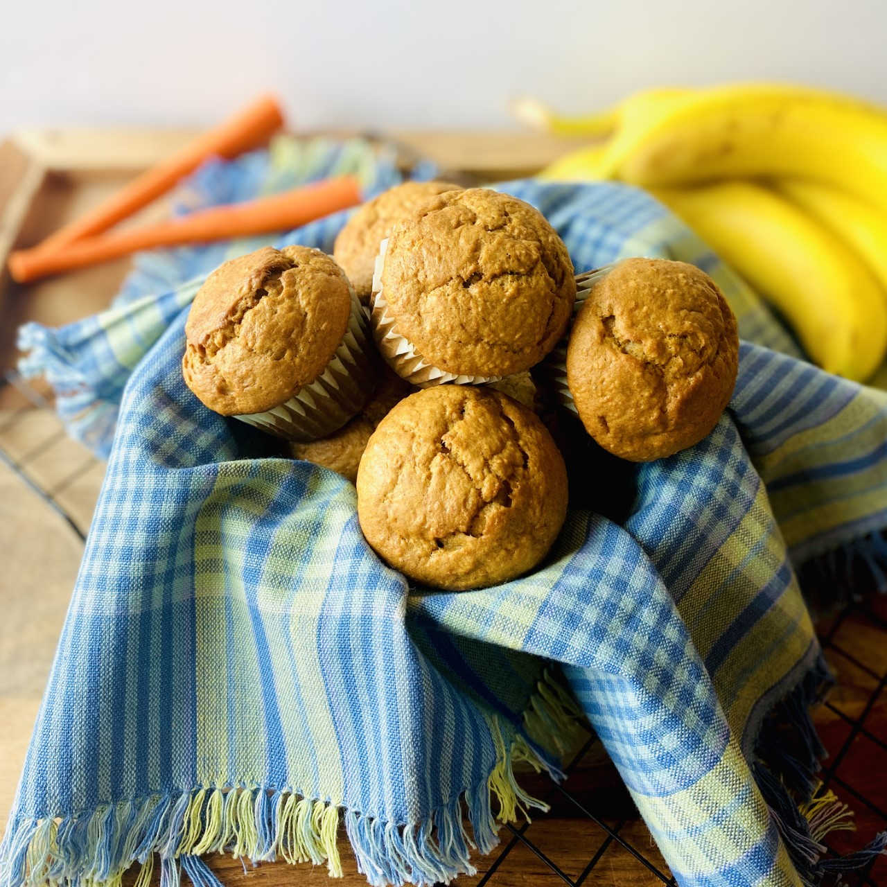 banana carrot muffins in basket with carrot and banana in background