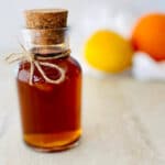 demerara syrup in bottle with lemon and orange in background