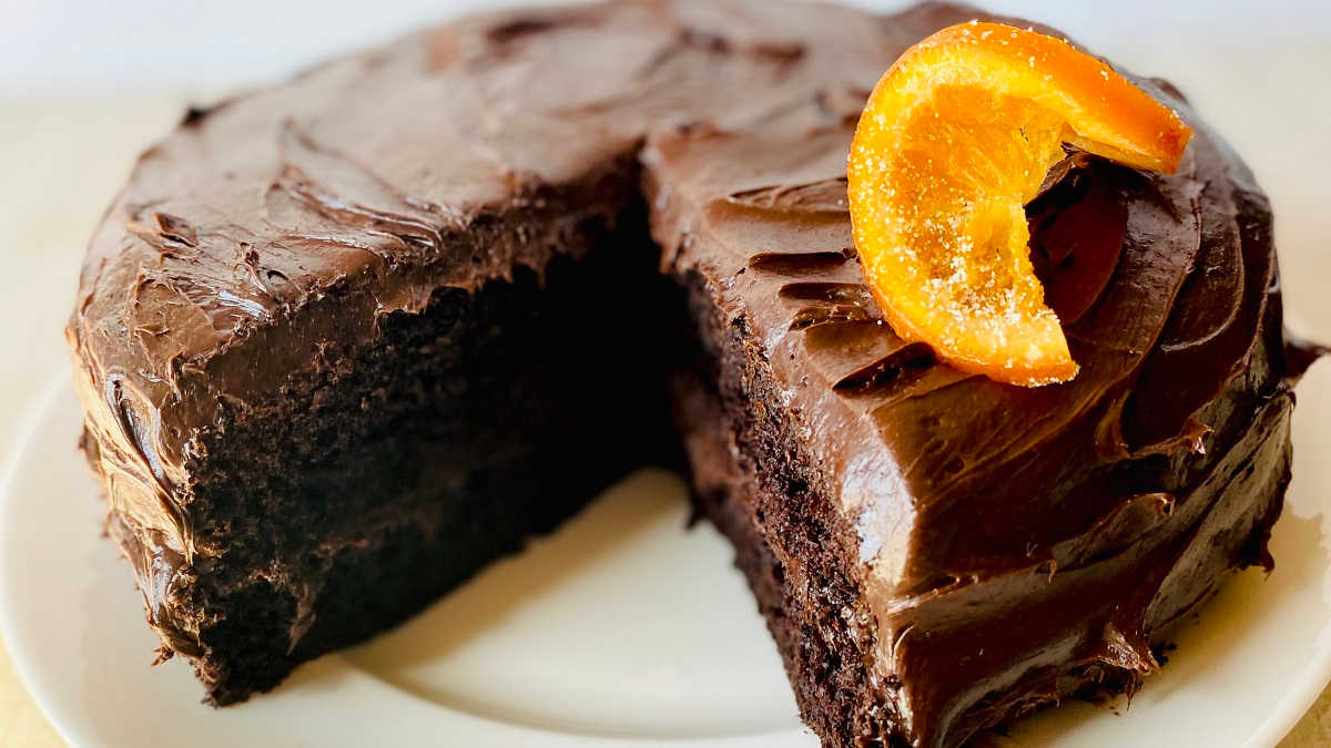 orange chocolate cake on a white plate garnished with a candied orange slice on top