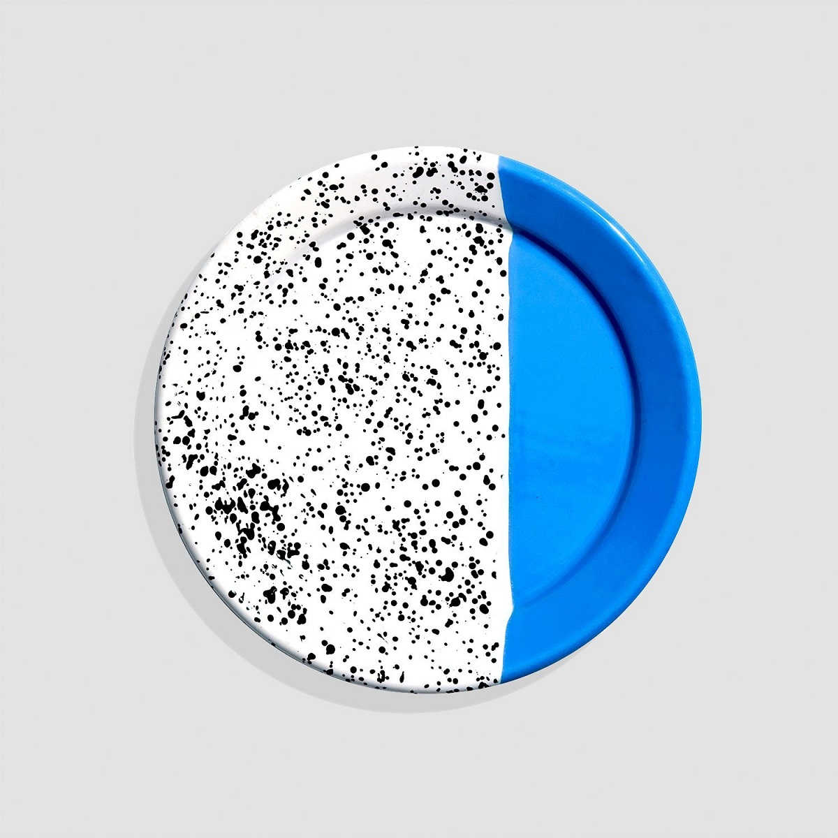 picture of a plate with vibrant colors, one half bright blue and the other half white with black speckles