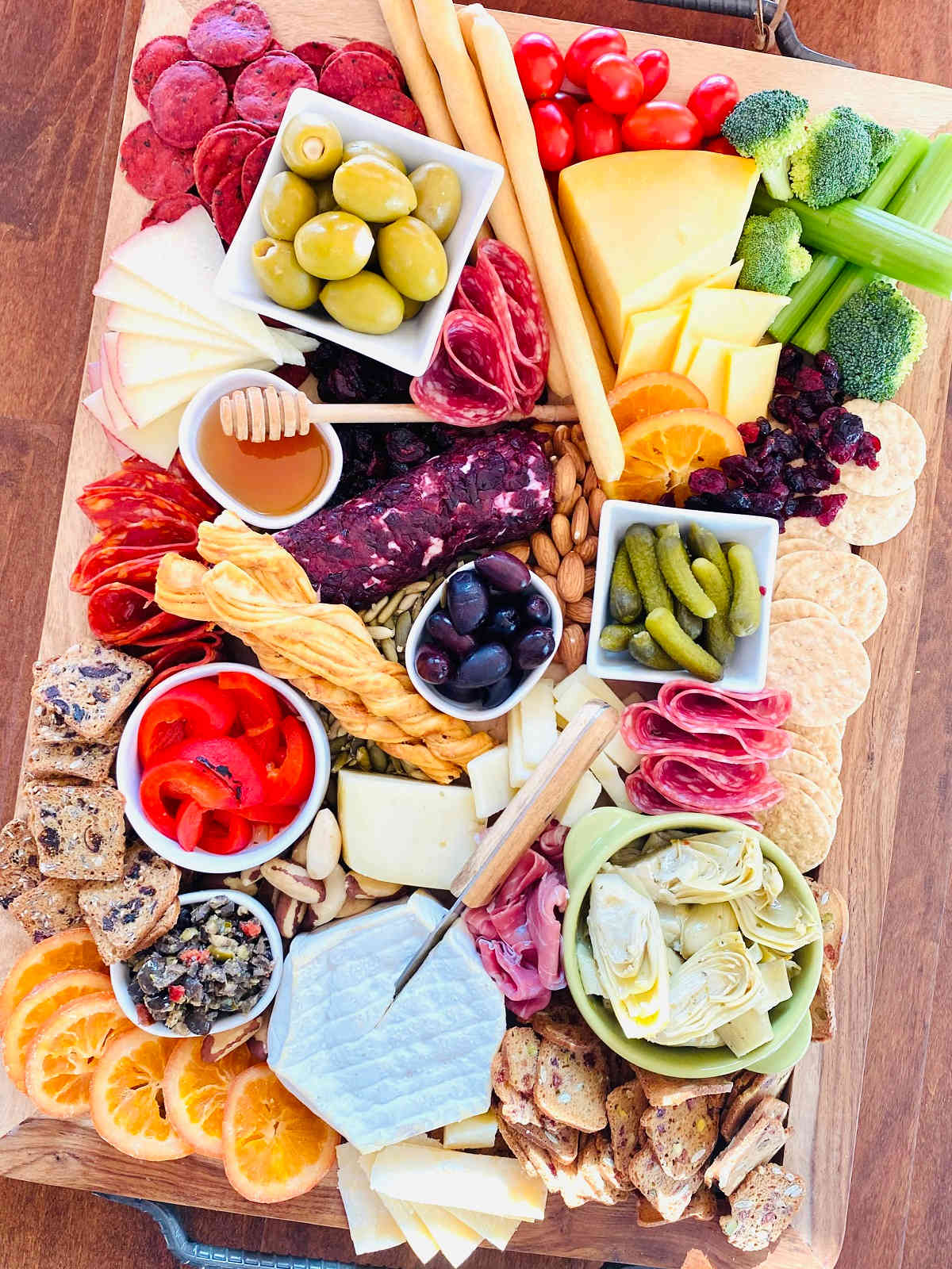 Charcuterie Board Trader Joe’s items with honey pickles red peppers vegetables nuts fruits cheese meat and dips and spreads