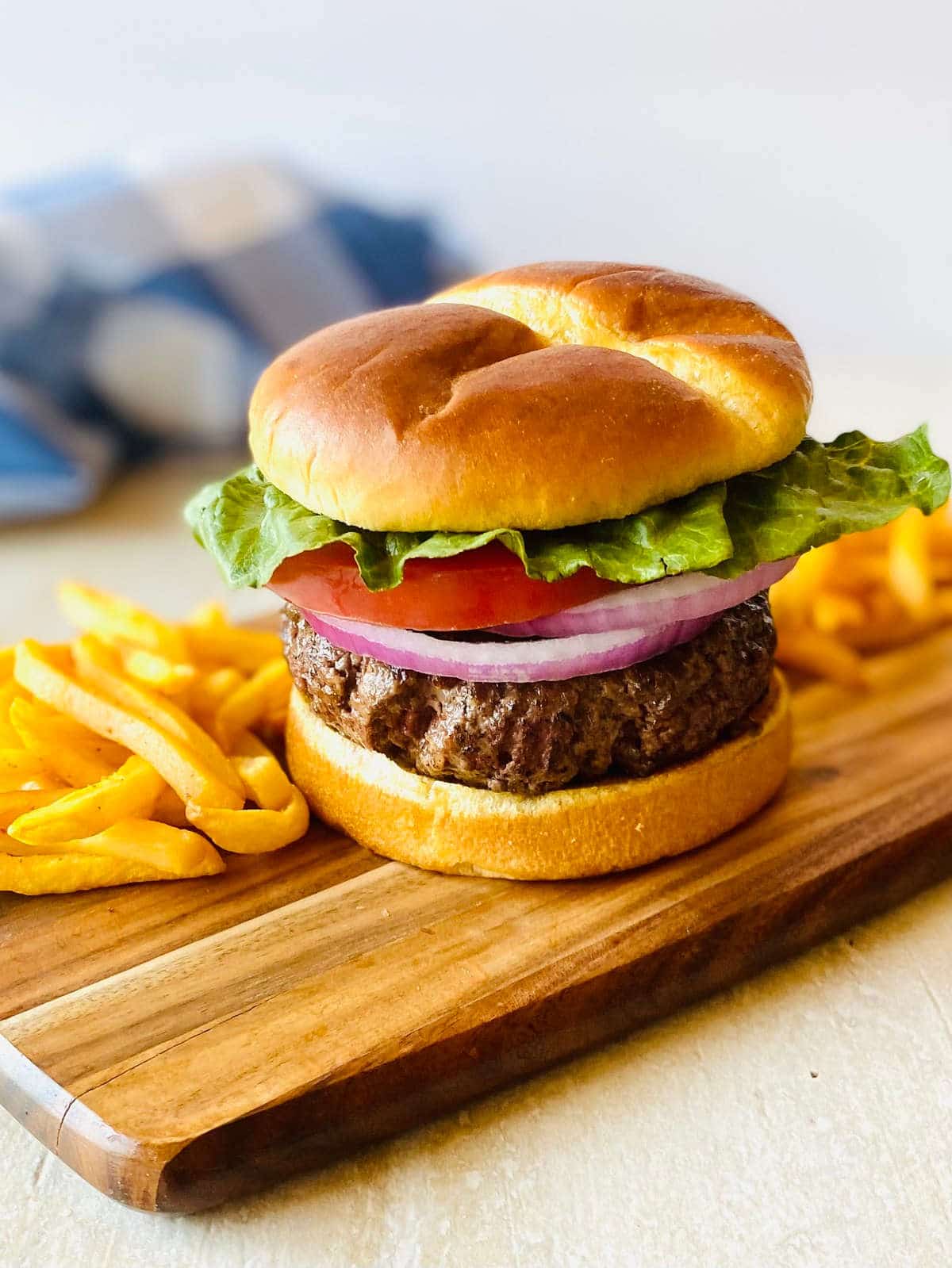 burger cooked frozen in air fryer on a cutting board with french fries