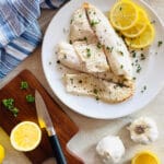 air fryer tilapia on a plate with lemon and parsley