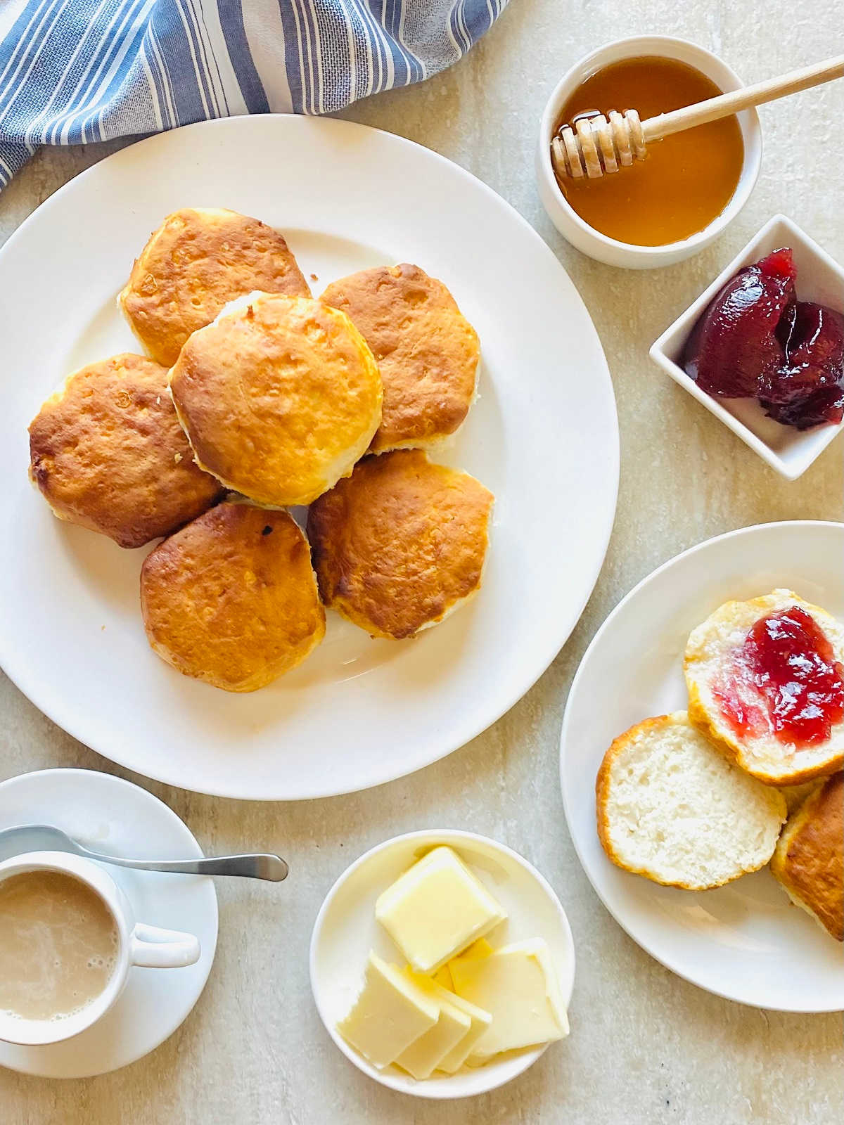 air fryer frozen biscuits on a plate next to honey, jam, butter and coffee