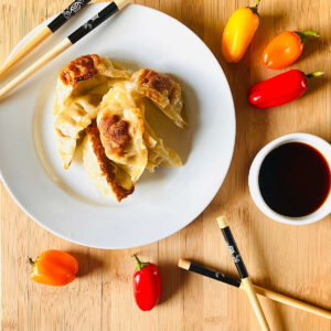 air fryer gyoza potstickers on a plate with chopsticks and soy sauce