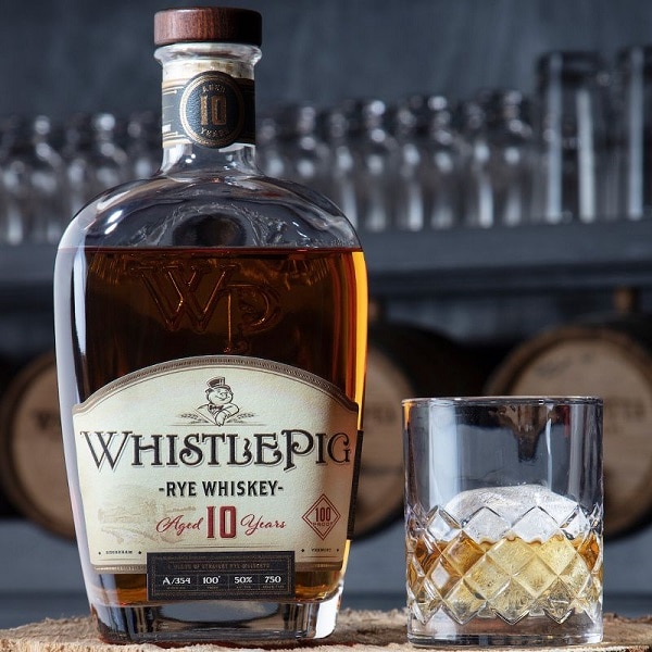 whistlepig whiskey bottle next to rocks glass with whiskey