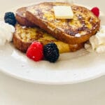 anabolic french toast protein french toast on plate with butter, berries and whipped cream