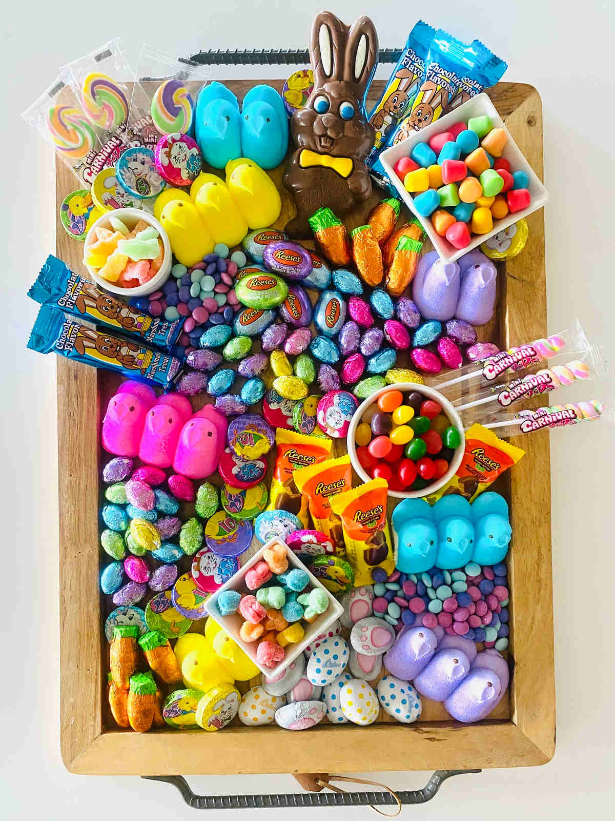 Easter Candy charcuterie Board with various Easter candy, chocolates, marshmallow peeps and gummies on a charcuterie board