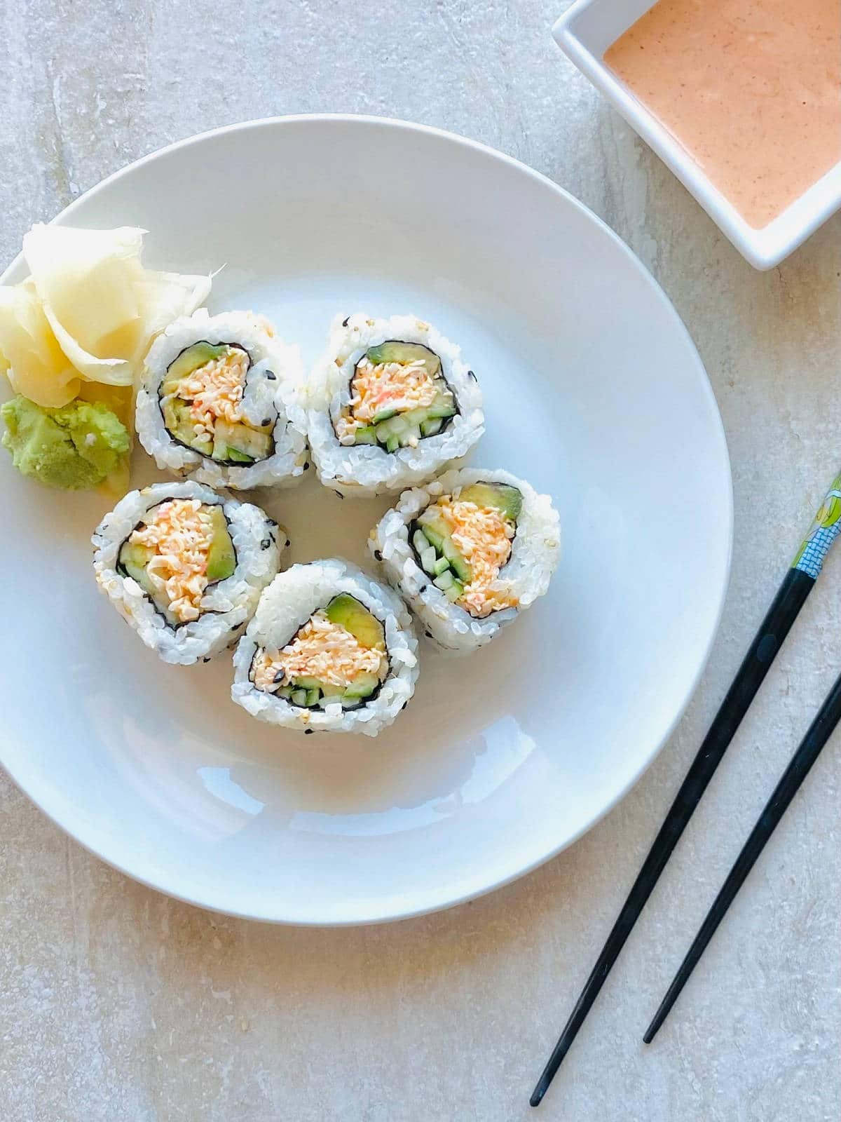 kani sushi roll on a plate with chopsticks