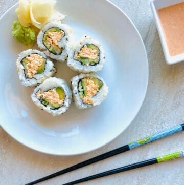 spicy crab roll on a plate with ginger and wasabi