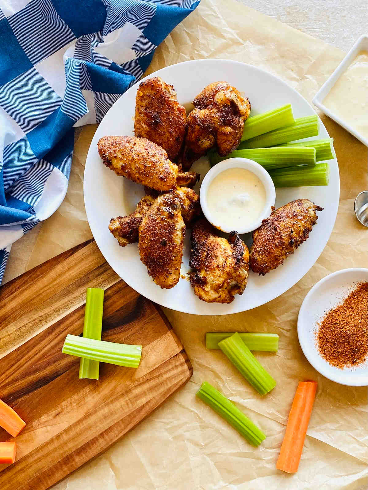baked cajun chicken wings on a plate with celery and ranch dressing