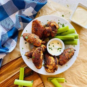 cajun wings recipe on a plate with celery and dip