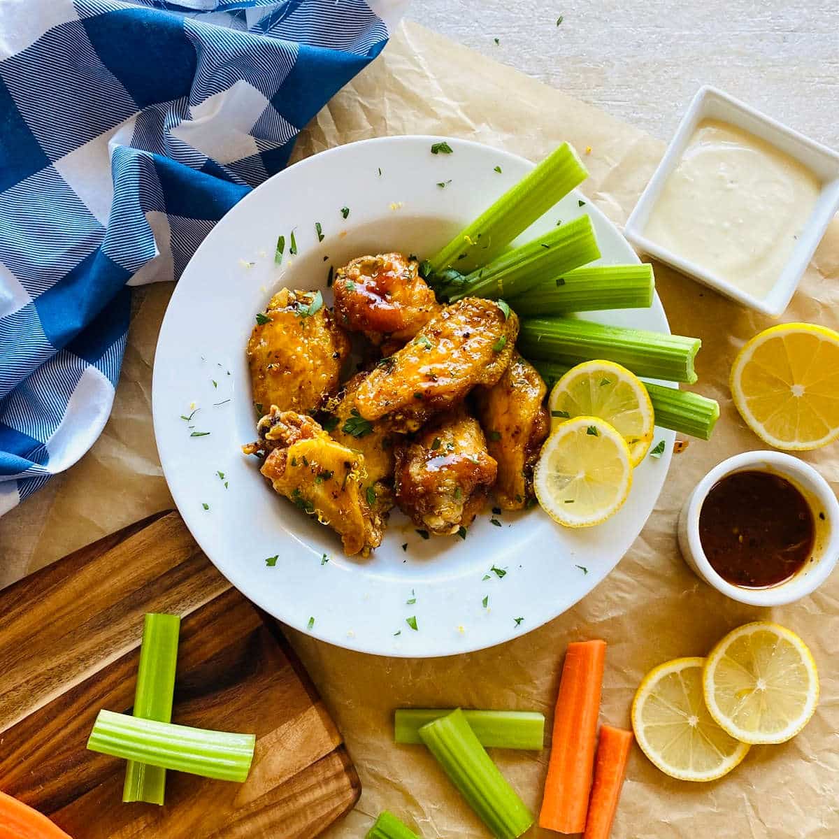 honey garlic lemon pepper sauce wings on a plate with celery, carrots and blue cheese dipping sauce