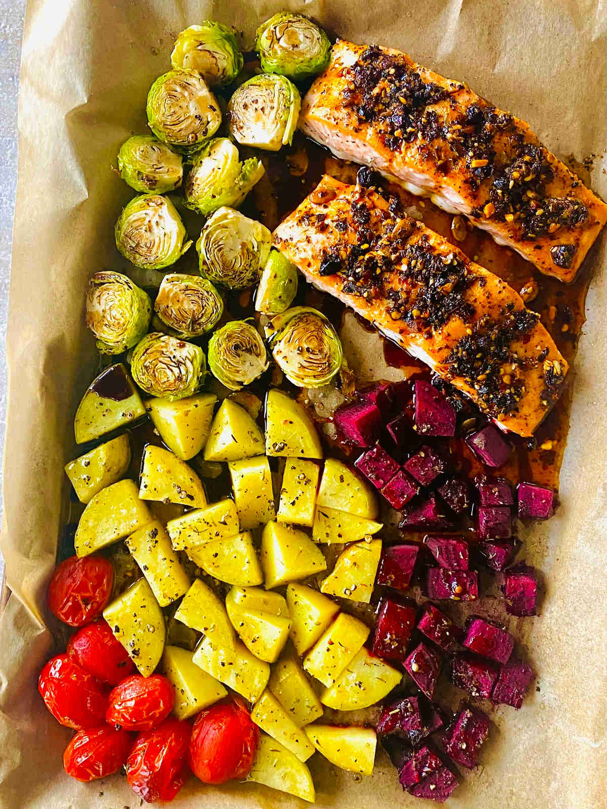 sheet pan salmon with potatoes, Brussels spouts, beets and tomatoes.