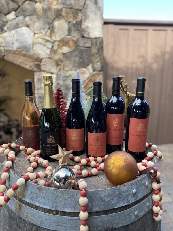 dutcher crossings wine bottles on a barrel with holiday decorations