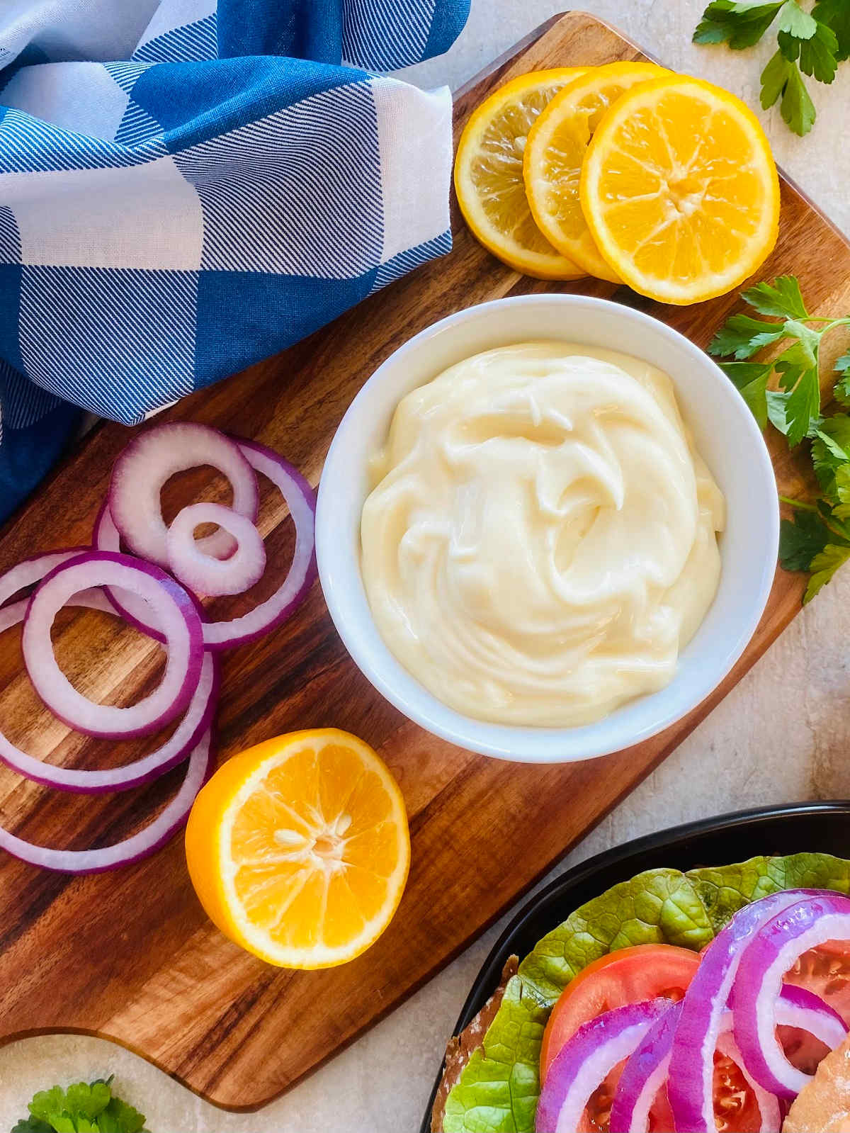 mayo recipe in a bowl next to lemon and sliced onion.