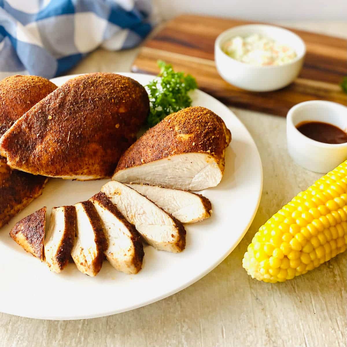 smoked chicken breast recipe with corn, bbq sauce and coleslaw on a plate.