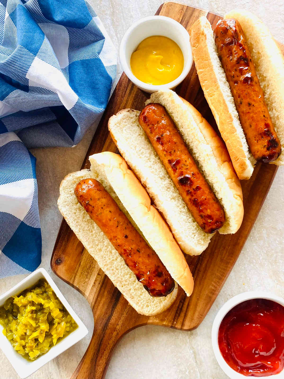 chicken sausage air fryer in buns with ketchup, relish and mustard.