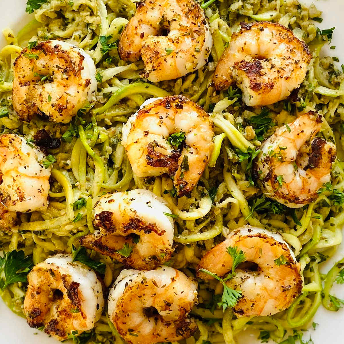 pesto without pine nuts on shrimp and zucchini noodles.