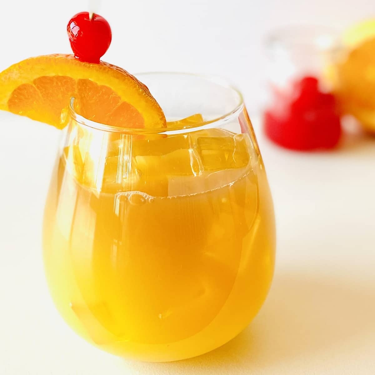 vodka sour recipe garnished with orange and cherry.